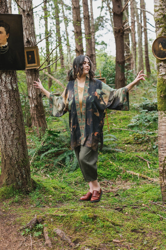Model wearing the Heartwork Cropped Kimono featuring Artemisia Gentileschi’s self-portrait with lush forest, birds, and butterflies – Market of Stars.