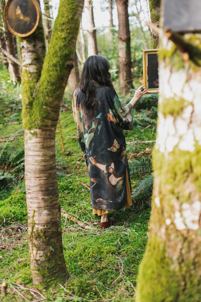 Model wearing the Heartwork Opera Duster featuring Artemisia Gentileschi’s self-portrait surrounded by forest, birds, and butterflies – Market of Stars.