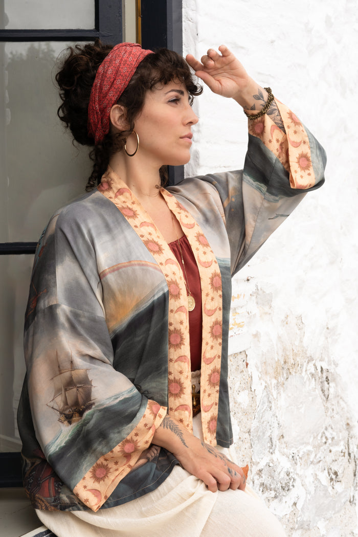 Model wearing the Hold Fast Pixie Duster featuring a Victorian woman rowing through a storm, seagulls, and rainbow horizon – Market of Stars.