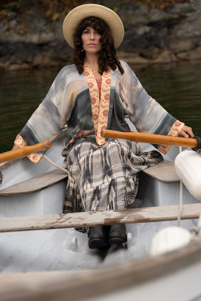 Model wearing the Hold Fast Pixie Duster featuring a Victorian woman rowing through a storm, seagulls, and rainbow horizon – Market of Stars.