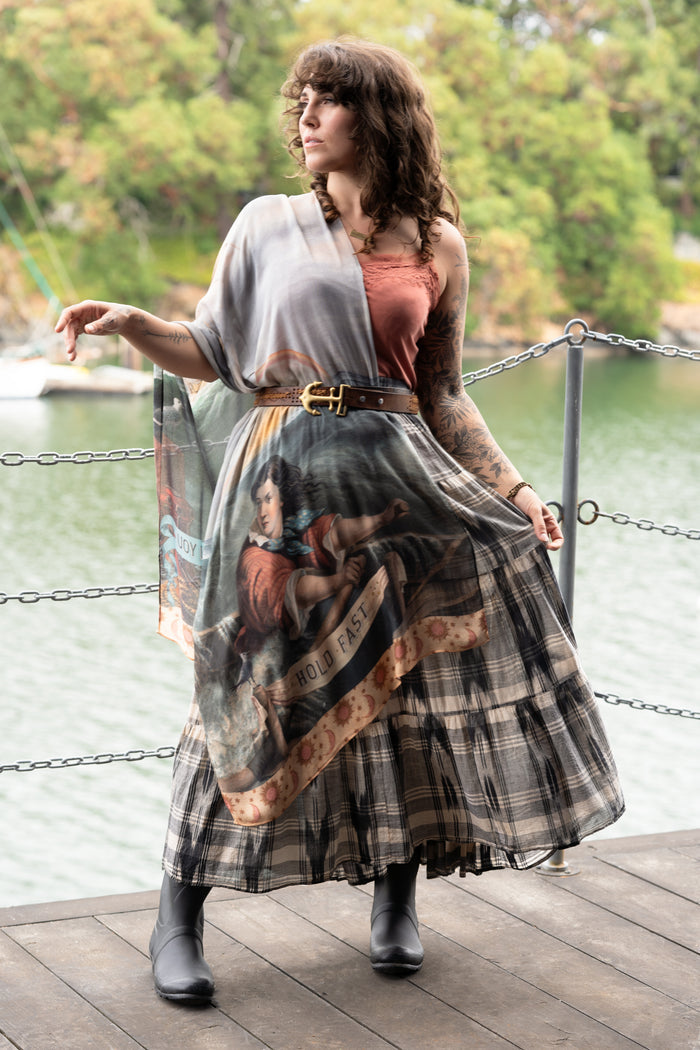 Model wearing the Hold Fast bamboo viscose scarf featuring a Victorian woman bravely rowing through a storm, seagulls, and rainbow horizon – Market of Stars.