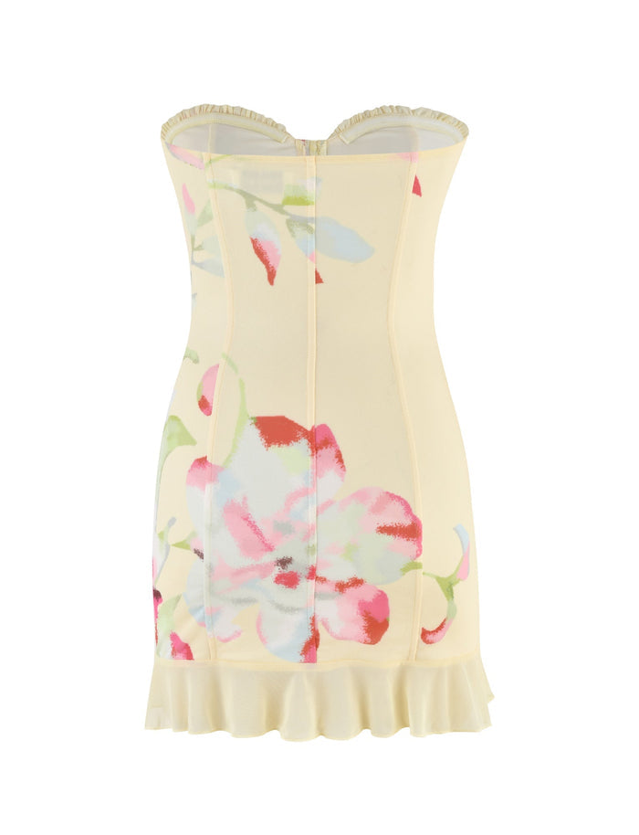 The HOLLIS DRESS - YELLOW : FLORAL : FEMME FLORAL by TIGERMIST showcases pink, red, and green floral patterns on a light yellow backdrop. This strapless mini dress is designed with structured seams and a ruffled hem, combining elegance with a playful charm.