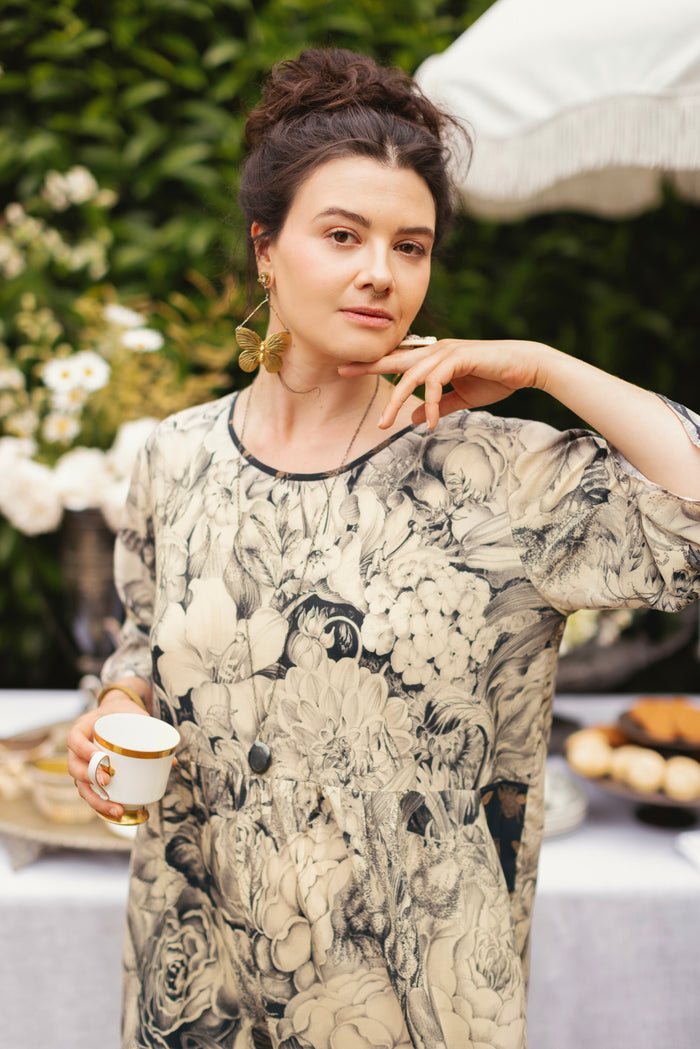 Model wearing a knee-length shift dress featuring black-and-ivory floral lithographs from the 1900's - Market of Stars