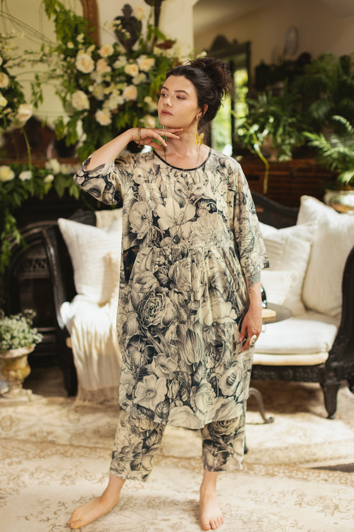 Model wearing a knee-length shift dress featuring black-and-ivory floral lithographs from the 1900's - Market of Stars