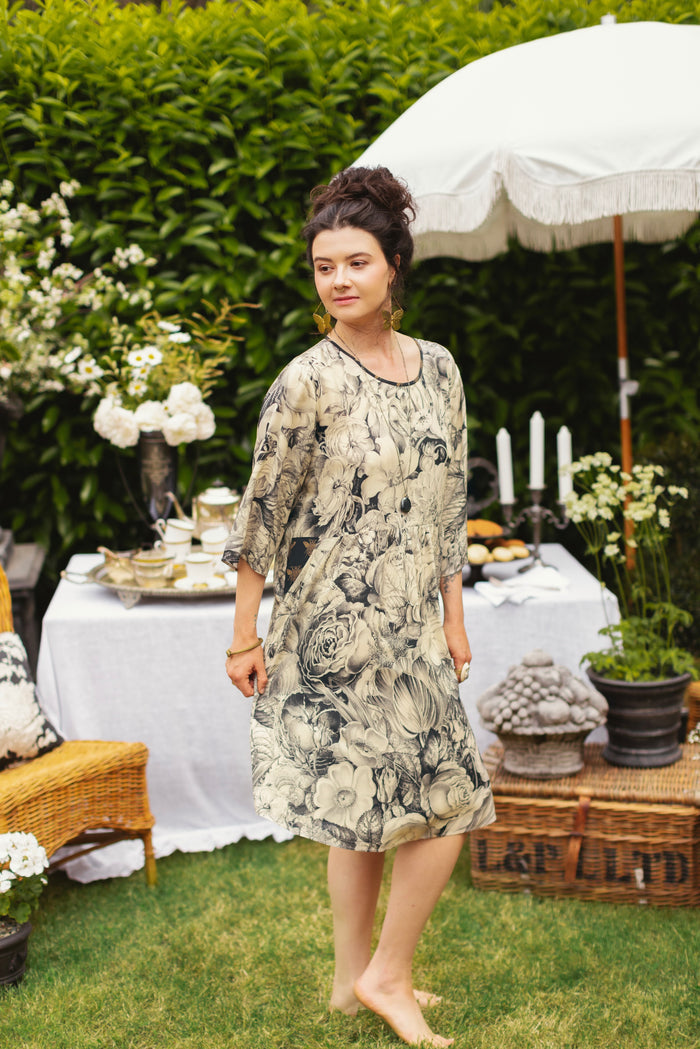 Model wearing a knee-length shift dress featuring black-and-ivory floral lithographs from the 1900's - Market of Stars