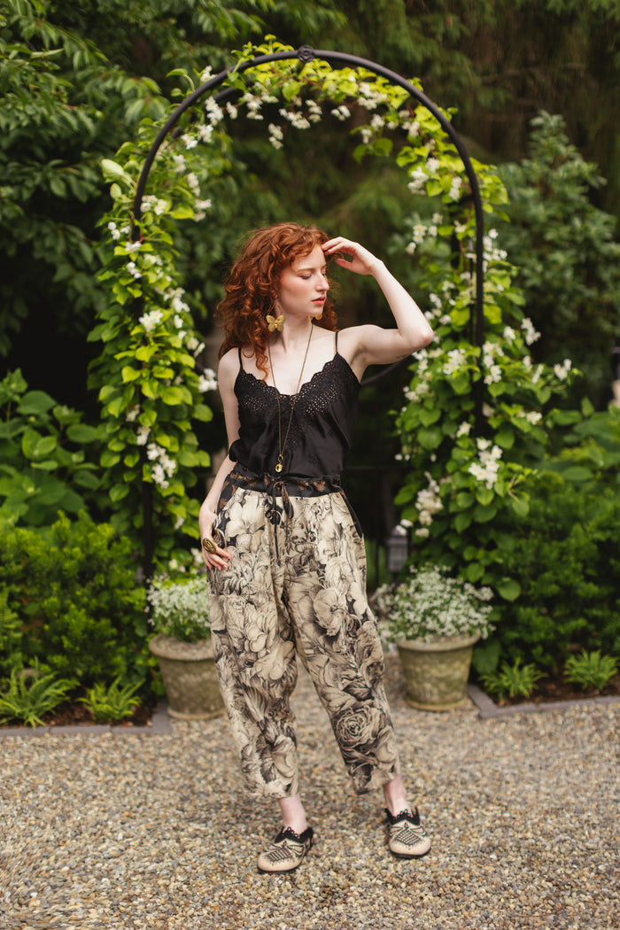Model wearing a cropped linen pant featuring black-and-ivory floral lithographs from the 1900's - Market of Stars