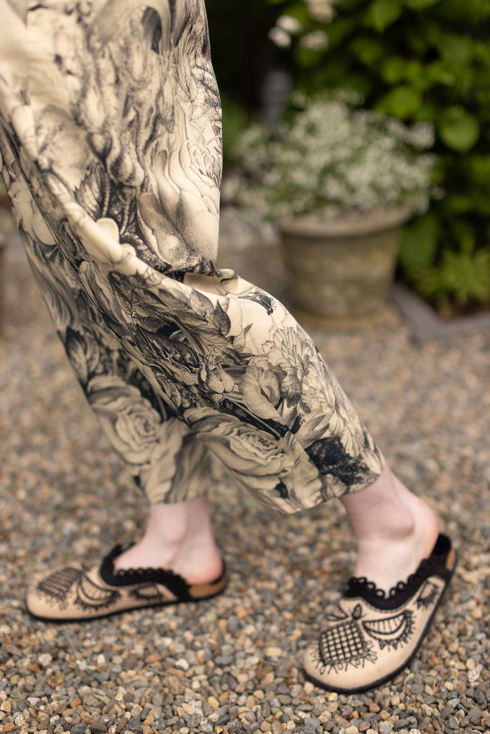 Model wearing a cropped linen pant featuring black-and-ivory floral lithographs from the 1900's - Market of Stars