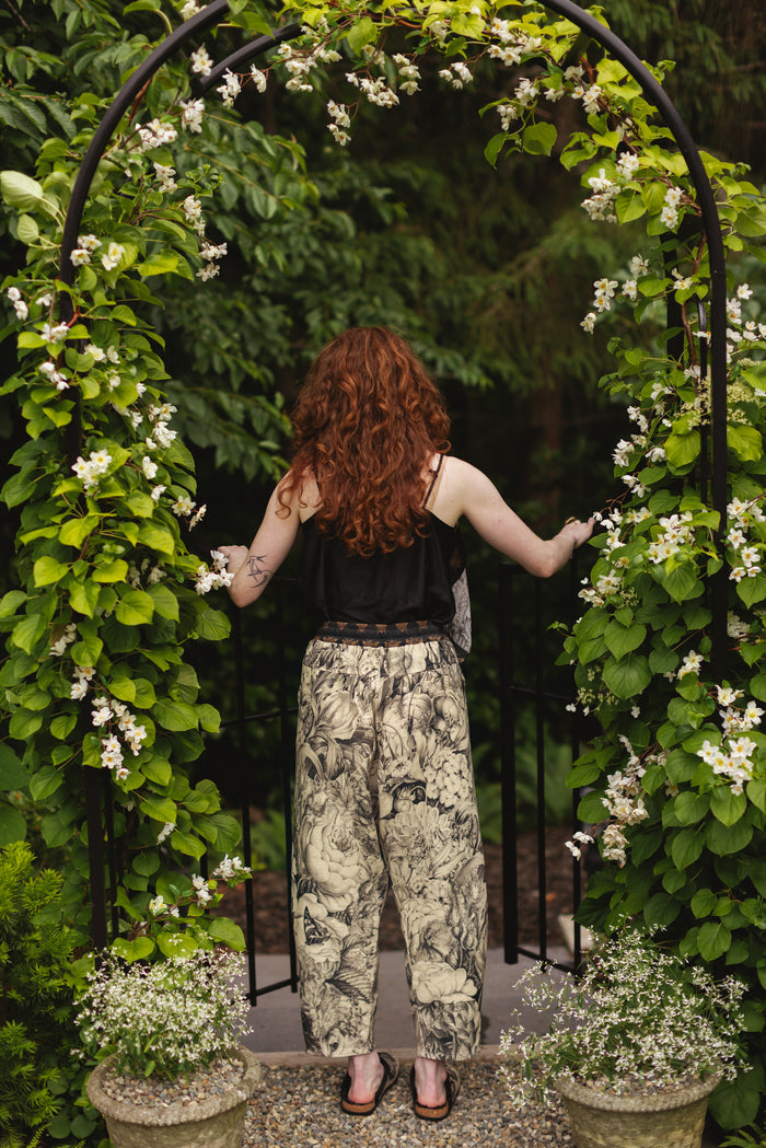 Model wearing a cropped linen pant featuring black-and-ivory floral lithographs from the 1900's - Market of Stars