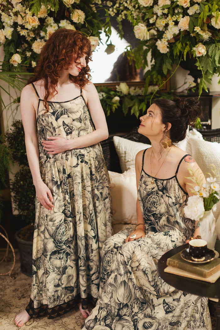 Model wearing a maxi-length slip dress featuring black-and-ivory floral lithographs from the 1900's - Market of Stars