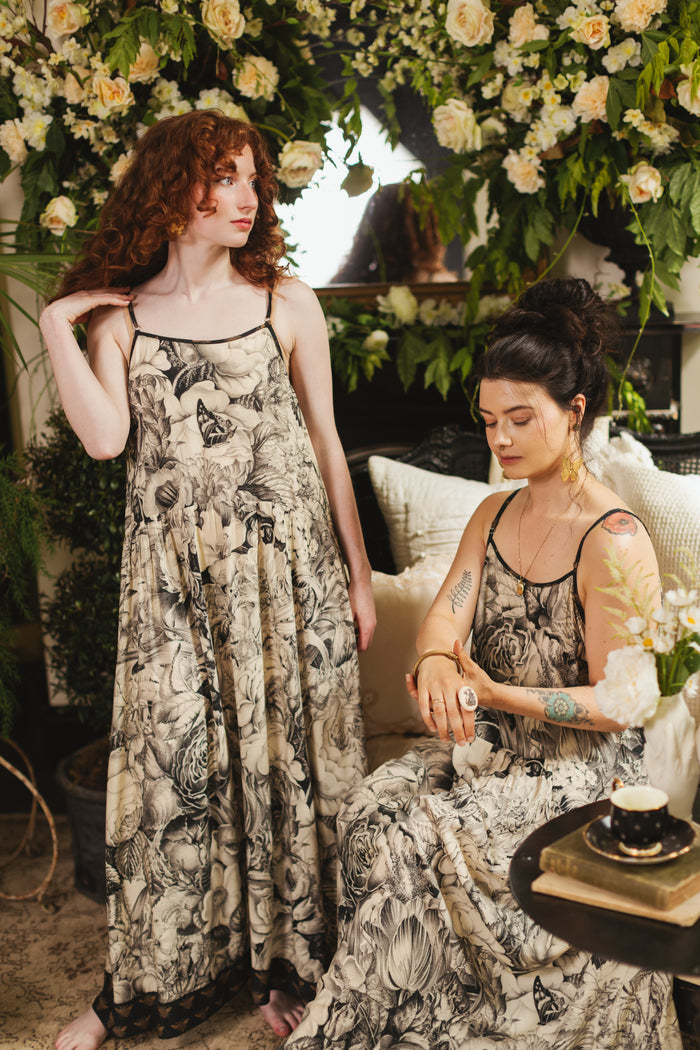 Model wearing a maxi-length slip dress featuring black-and-ivory floral lithographs from the 1900's - Market of Stars