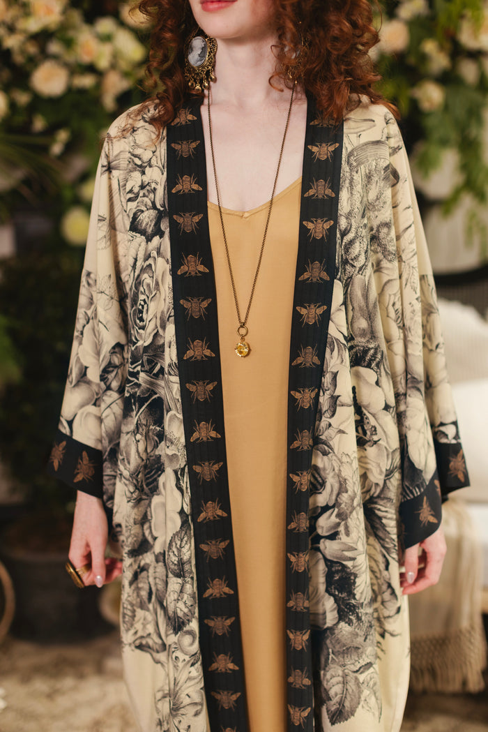 Model wearing a full-length opera duster featuring black-and-ivory floral lithographs from the 1900's - Market of Stars
