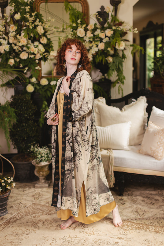 Model wearing a full-length opera duster featuring black-and-ivory floral lithographs from the 1900's - Market of Stars