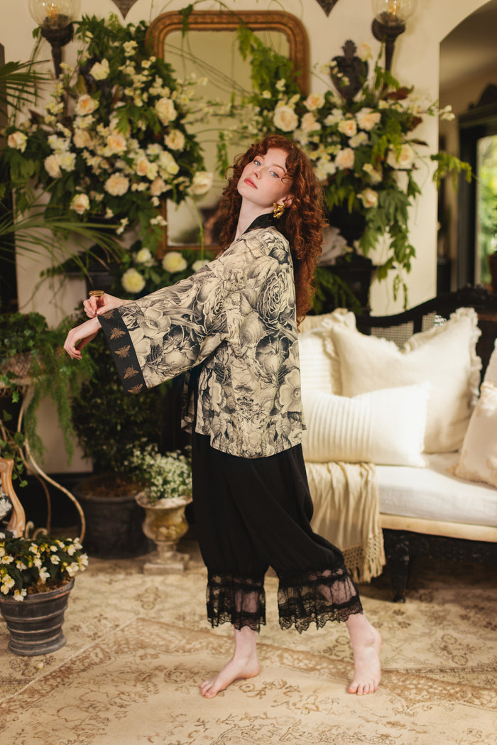 Model wearing a cropped length duster featuring black-and-ivory floral lithographs from the 1900's - Market of Stars