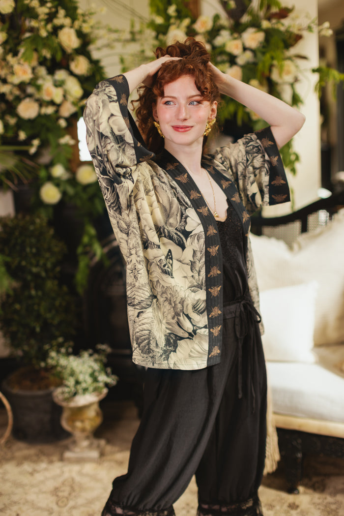 Model wearing a cropped length duster featuring black-and-ivory floral lithographs from the 1900's - Market of Stars
