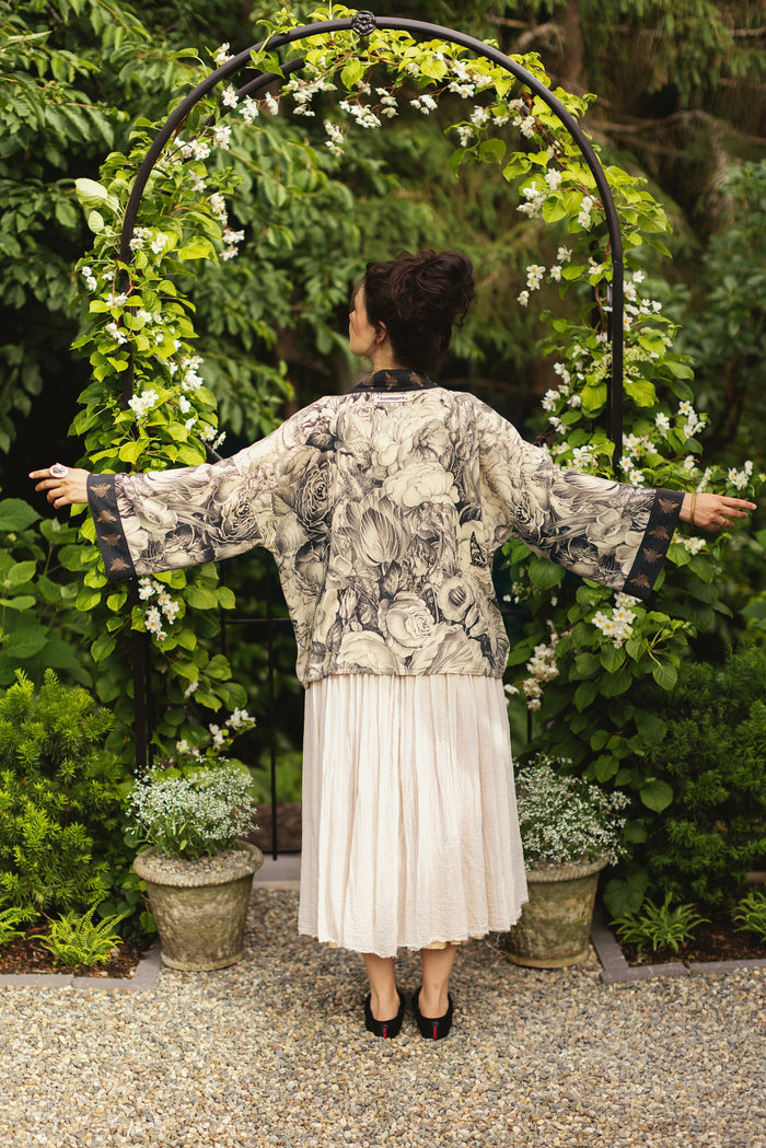 Model wearing a cropped length duster featuring black-and-ivory floral lithographs from the 1900's - Market of Stars