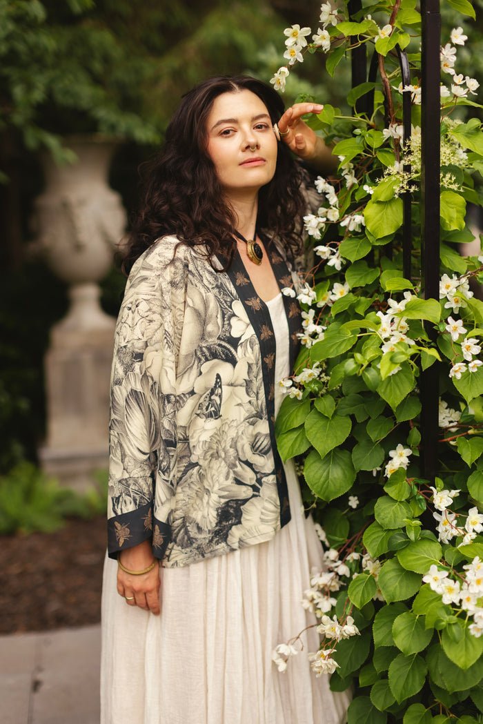 Model wearing a cropped length duster featuring black-and-ivory floral lithographs from the 1900's - Market of Stars