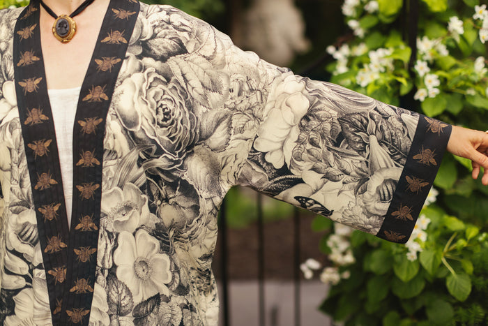 Model wearing a cropped length duster featuring black-and-ivory floral lithographs from the 1900's - Market of Stars