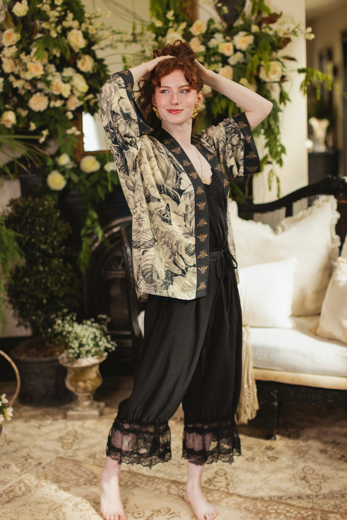 Model wearing a cropped length duster featuring black-and-ivory floral lithographs from the 1900's - Market of Stars
