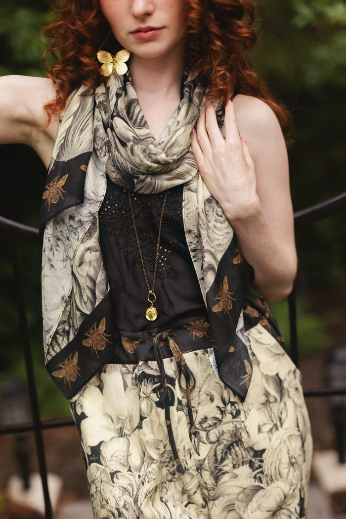 Model wearing a bamboo-viscose scarf featuring black-and-ivory floral lithographs from the 1900's - Market of Stars