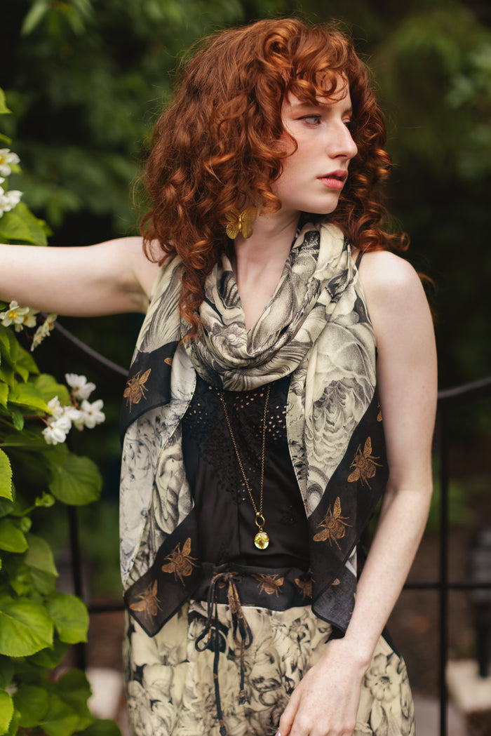 Model wearing a bamboo-viscose scarf featuring black-and-ivory floral lithographs from the 1900's - Market of Stars