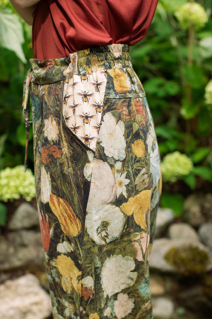 Model wearing the I Dream in Flowers Artist Pants featuring romantic floral artwork by Jan Brueghel and Victorian bumblebee trim, styled for everyday ease – Market of Stars