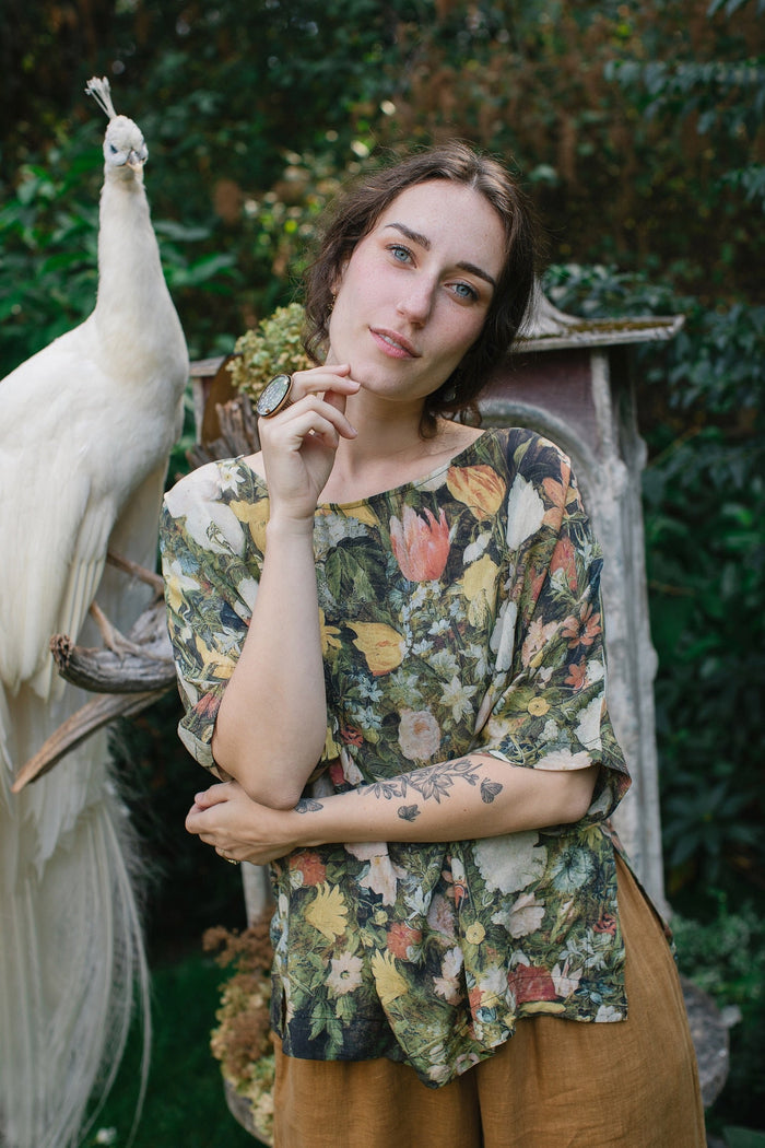 Model wearing the I Dream in Flowers Luxe Tee featuring painterly florals by Jan Brueghel and hidden bumblebee trim – Market of Stars.