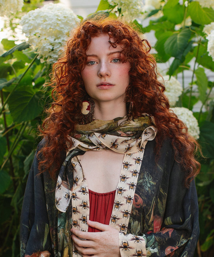 Model wearing the I Dream in Flowers Scarf featuring lush floral art by Jan Brueghel and charming Victorian bumblebees – Market of Stars.