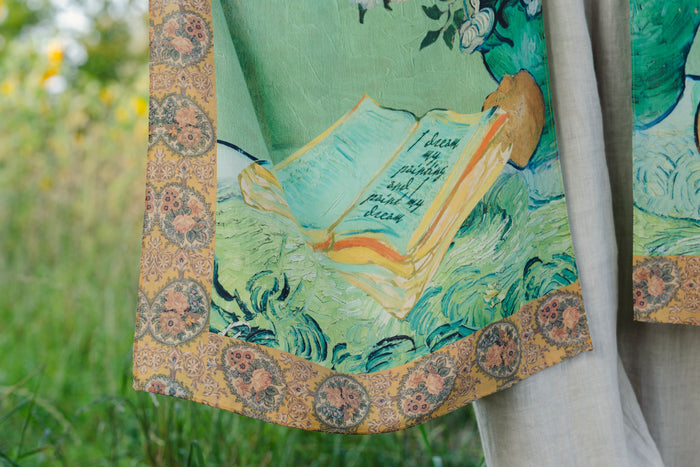 Model wearing mid-length duster featuring Van Gogh artwork and quote, with painted blossoms, book, sun, and eye in rich tones of jade and gold - Market of Stars