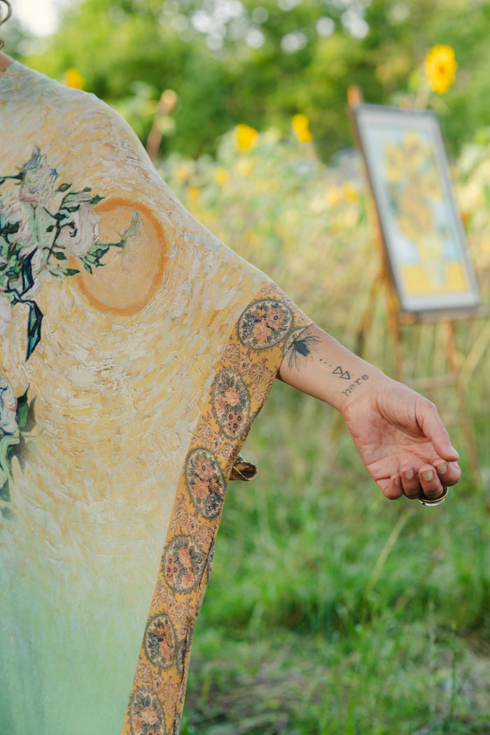 Model wearing mid-length duster featuring Van Gogh artwork and quote, with painted blossoms, book, sun, and eye in rich tones of jade and gold - Market of Stars