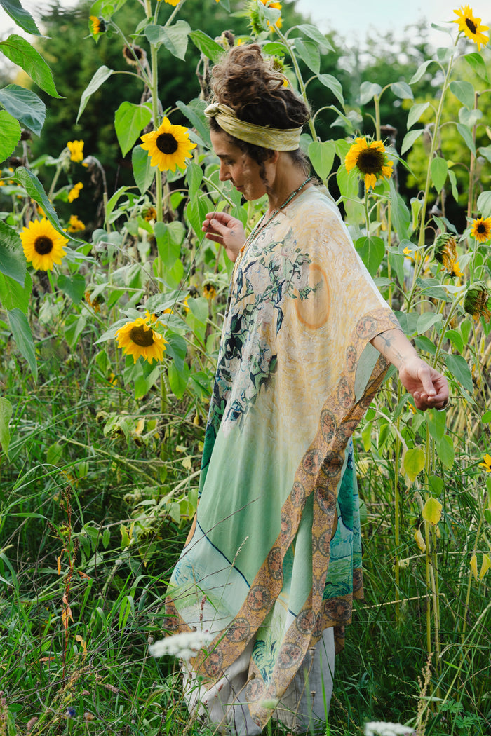 Model wearing mid-length duster featuring Van Gogh artwork and quote, with painted blossoms, book, sun, and eye in rich tones of jade and gold - Market of Stars
