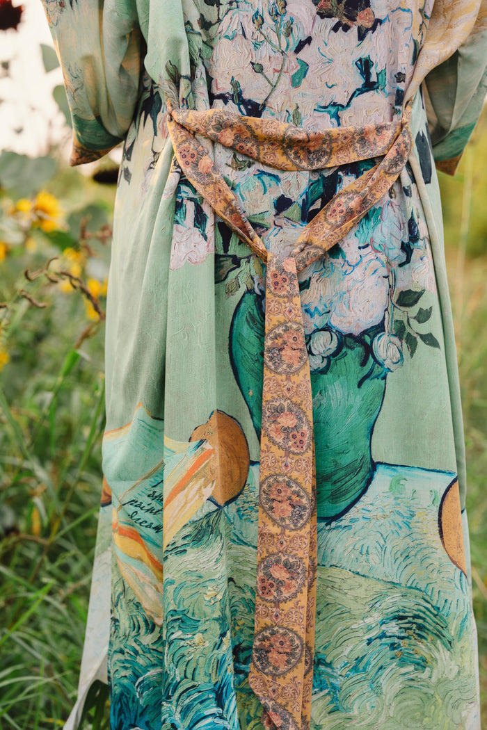 Model wearing long kimono duster featuring Van Gogh artwork and quote, with painted blossoms, book, sun, and eye in rich tones of jade and gold - Market of Stars