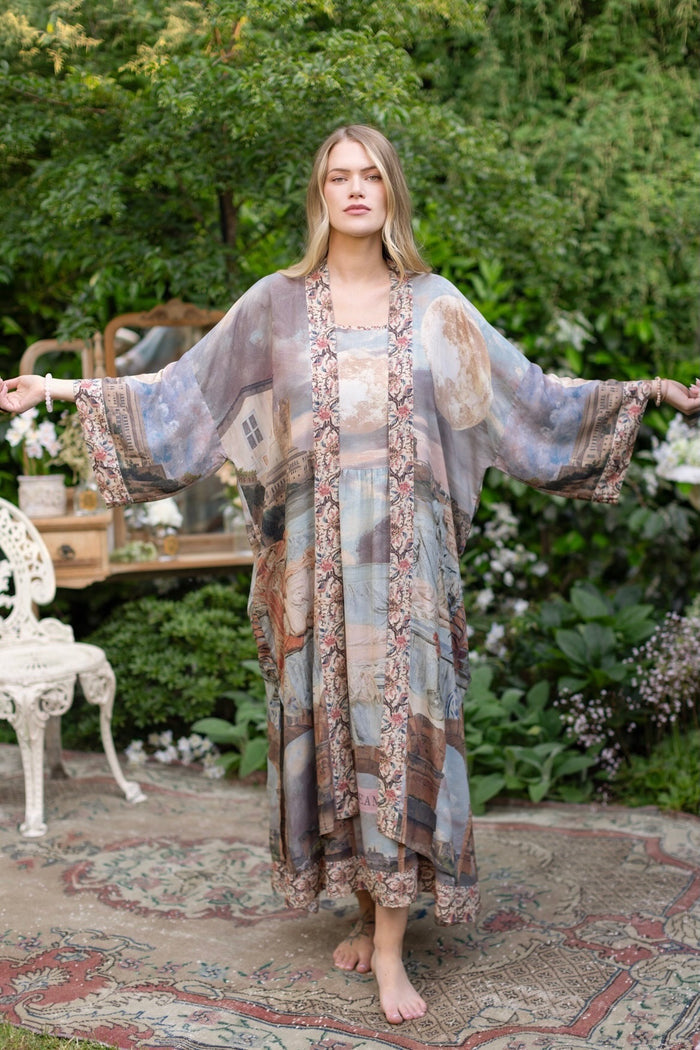 Model standing in airy Imaginarium opera duster featuring layered dreamscape art, candlelit chandelier, and sleeping muse inspired by Victorian paintings – Market of Stars