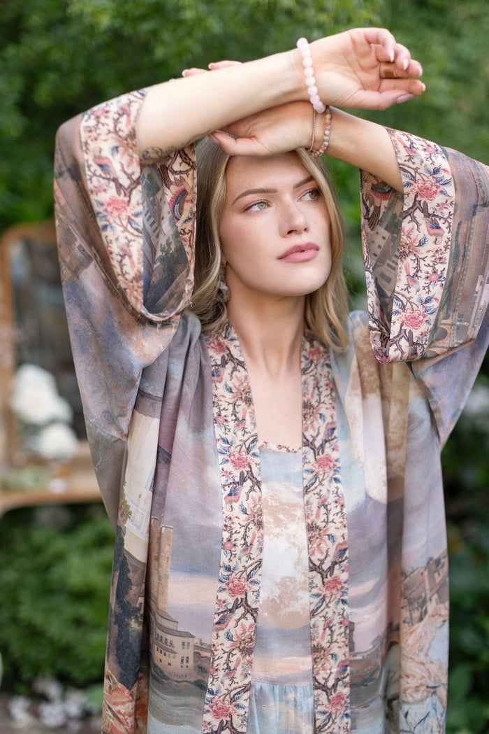 Model standing in airy Imaginarium opera duster featuring layered dreamscape art, candlelit chandelier, and sleeping muse inspired by Victorian paintings – Market of Stars