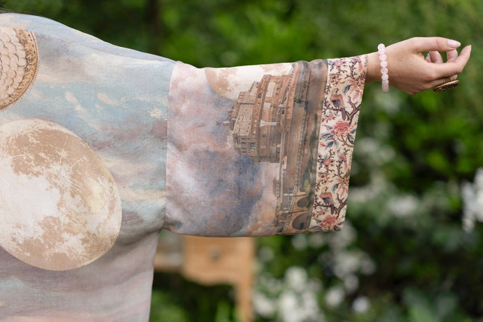 Model standing in airy Imaginarium opera duster featuring layered dreamscape art, candlelit chandelier, and sleeping muse inspired by Victorian paintings – Market of Stars