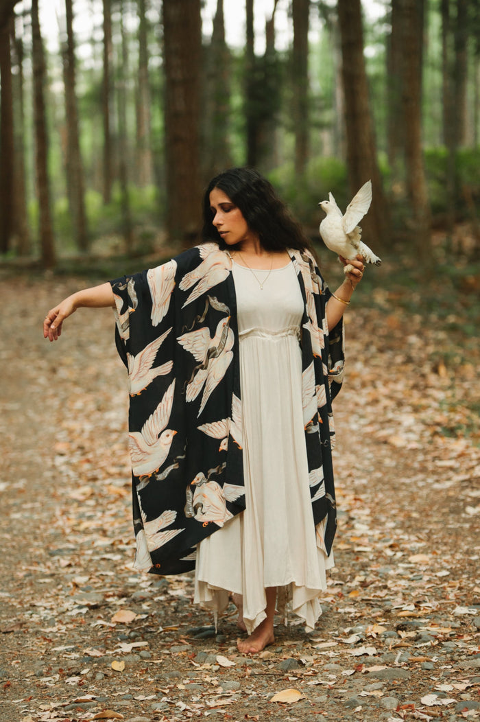 Model wearing the original Market of Stars kimono featuring Victorian-inspired doves and the words “In Stardust We Trust” — a tribute to dreams and possibility – Market of Stars.