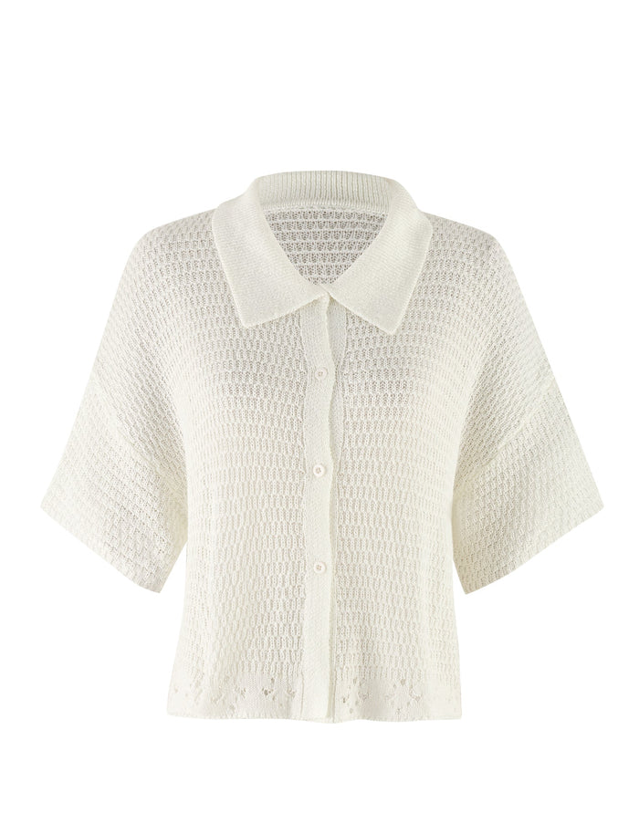 The JANAI TOP - WHITE : CREAM from TIGERMIST is a white, short-sleeved knit cardigan with a textured pattern. It features a button-up front and V-neckline, offering a relaxed, airy appearance with an oversized fit that makes it perfect for layering in warmer weather.