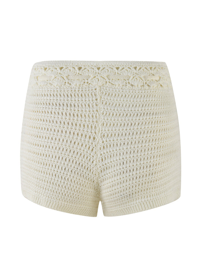 Rear view of the JONAS SHORT - WHITE : CREAM by TIGERMIST, showcasing its textured knit design and a floral lace waistband. These super mini crochet shorts are shown on a plain white background, highlighting the contrast stitch detail beautifully.