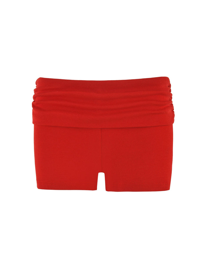 Introducing the TIGERMIST KARINA RIB SHORT - RED, showcasing a red ruched waistband and ribbed fabrication for a seamless look. The stretchable, form-fitting fabric ensures a comfortable fit, ideal for both casual and athletic occasions. Its vibrant color coupled with a low-rise waist adds a bold touch to any outfit.