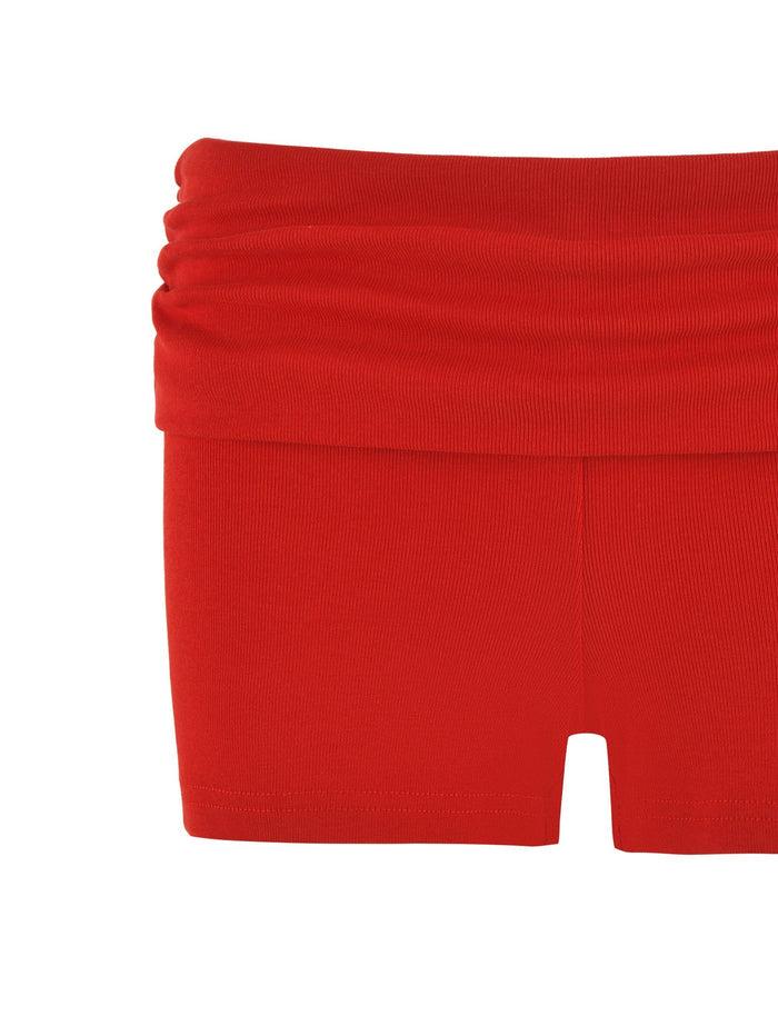 The KARINA RIB SHORT - RED by TIGERMIST boasts a stylish low-rise waist and ribbed design, highlighted elegantly against a plain white background with its distinctive ruched waistband.