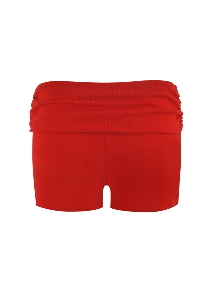 Presented is the KARINA RIB SHORT - RED by TIGERMIST, showcasing a striking bright red color. These women's shorts feature a high-waisted, ruched band and are crafted from ribbed fabrication. The smooth, stretchy fabric guarantees a comfortable fit. Displayed from the front against a white background.