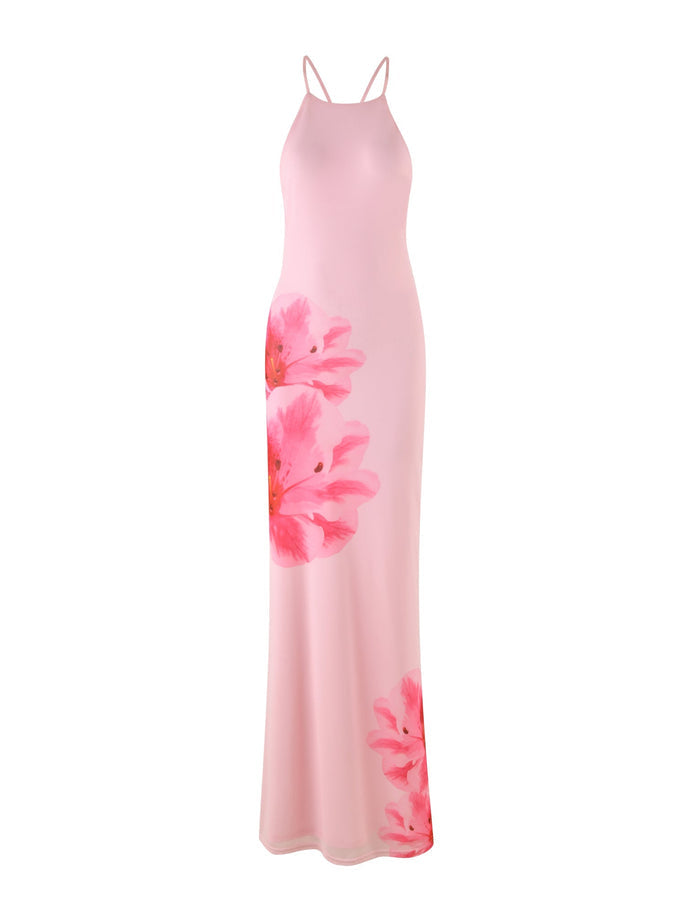 Introducing the KARTER DRESS - PINK : BABY PINK by TIGERMIST: A stunning long, sleeveless maxi dress with delicate spaghetti straps. It showcases large, vibrant floral patterns strategically placed on the left side and near the bottom hem. The dress features a fitted top and a flowing skirt, crafted from lightweight mesh fabric for an effortlessly airy feel.
