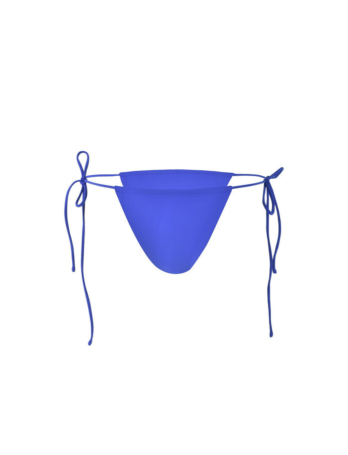 A bright cobalt blue KHESSA BIKINI BOTTOM from TIGERMIST, featuring side tie strings and showcased against a plain white background. This garment boasts a simple, minimalist design.