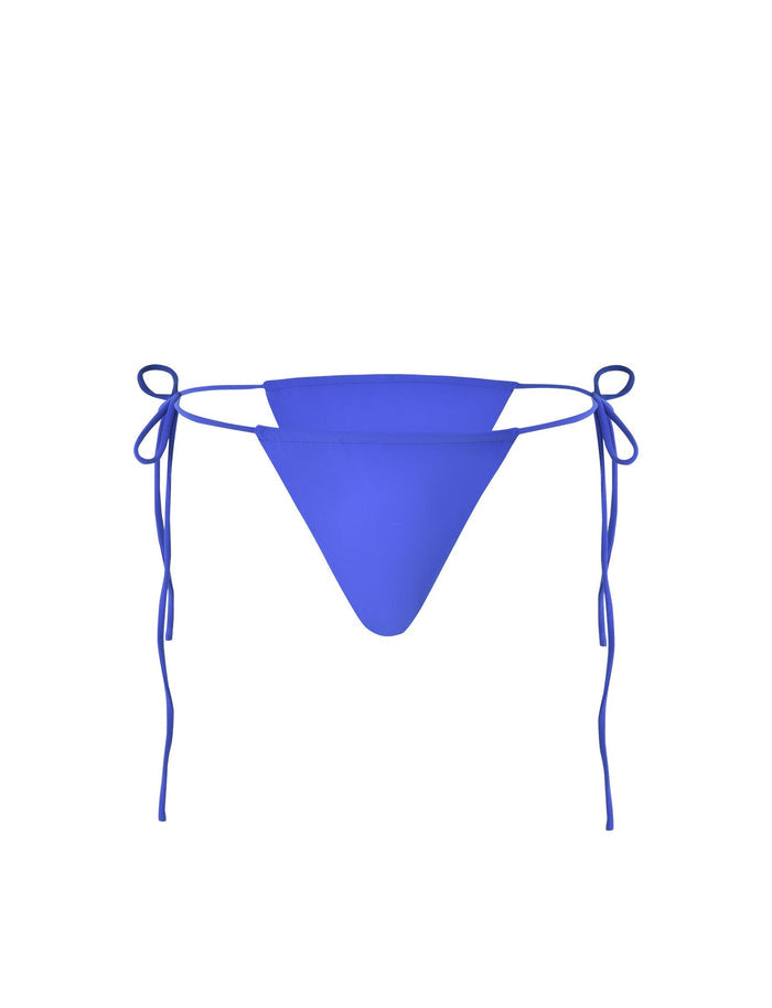 A KHESSA BIKINI BOTTOM - BLUE : COBALT from TIGERMIST is pictured against a white background. It has a triangular shape with thin strings on both sides, tied into bows.