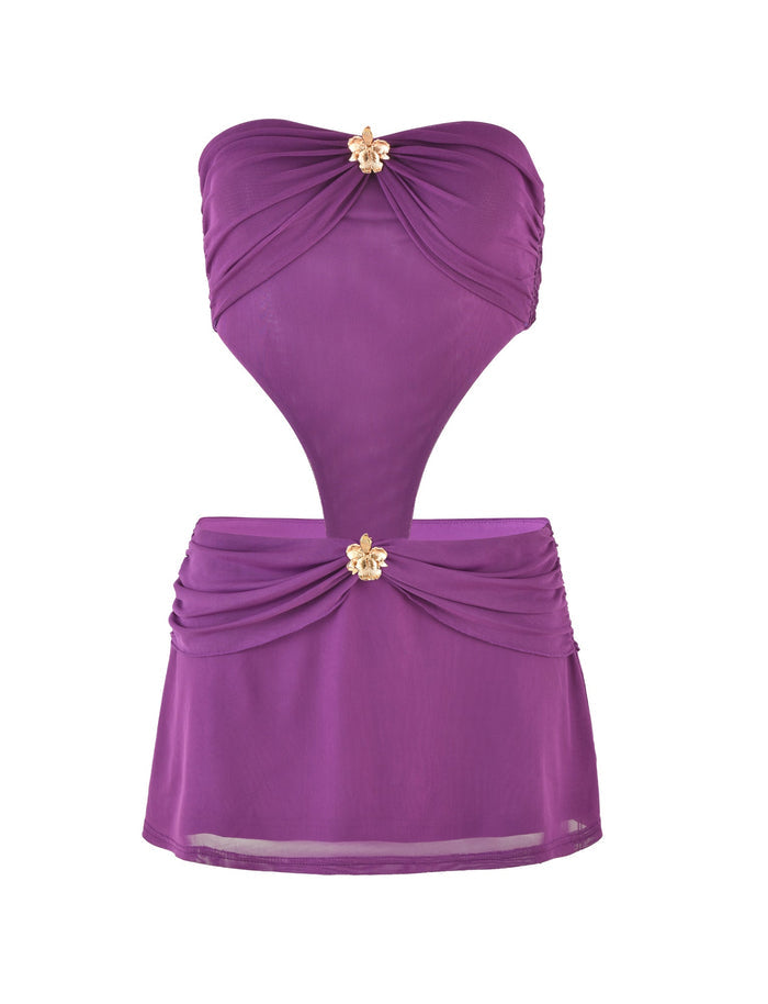 The TIGERMIST KYNLEE MINI DRESS - PURPLE is a strapless mini dress, highlighted by floral gold hardware at the bust and waist. Its design includes a cut-out midsection with a skirted bottom, making it an ideal beach cover-up.