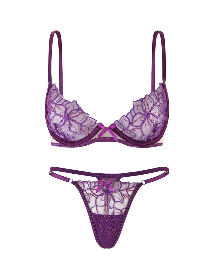 The LAURA SET - PURPLE : LAVENDER by TIGERMIST features a lace bra adorned with floral embroidery and delicate, adjustable shoulder straps, paired with matching lace panties showcasing similar floral patterns and thin side straps. The set is displayed against a white background.
