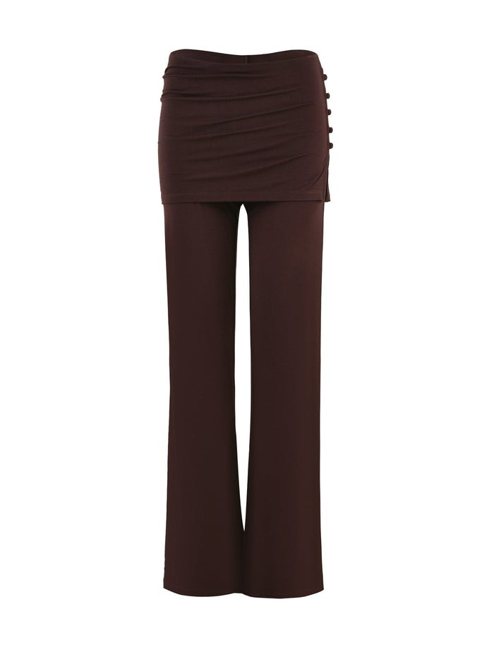 The LEILANI PANT - BROWN: CHOCOLATE by TIGERMIST is a pair of dark chocolate wide-leg pants made from high stretch fabric, featuring a fitted, ruched waistband and decorative buttons on the side.