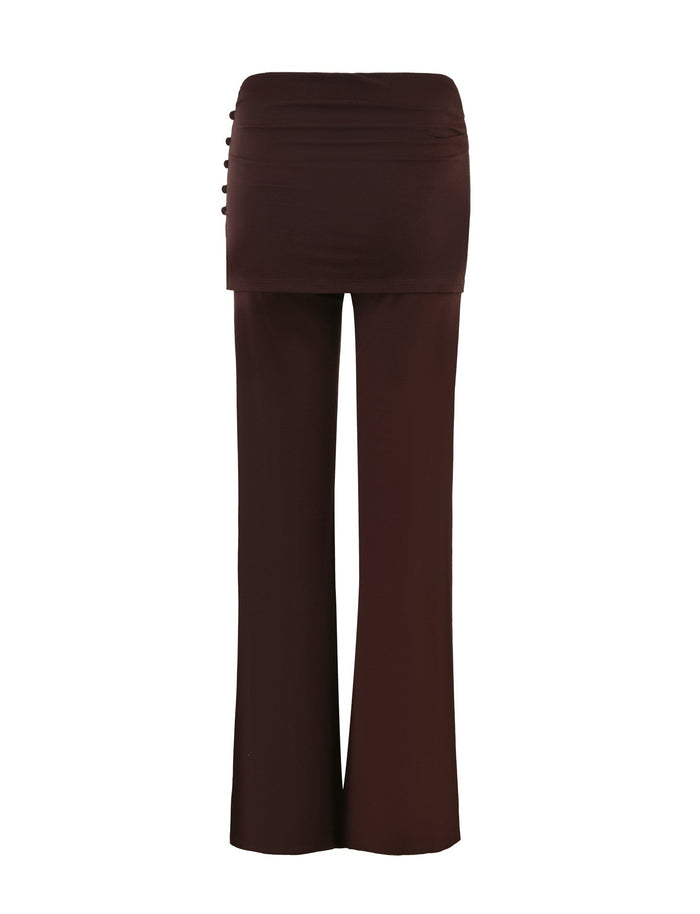 Introducing the LEILANI PANT - BROWN : CHOCOLATE by TIGERMIST, a chic high-waisted skirt-pants ensemble featuring a mini skirt overlay and flared leg trousers. The design is enhanced with side waist button details and crafted from high-stretch fabric for ultimate comfort, offering a stylish layered appearance.