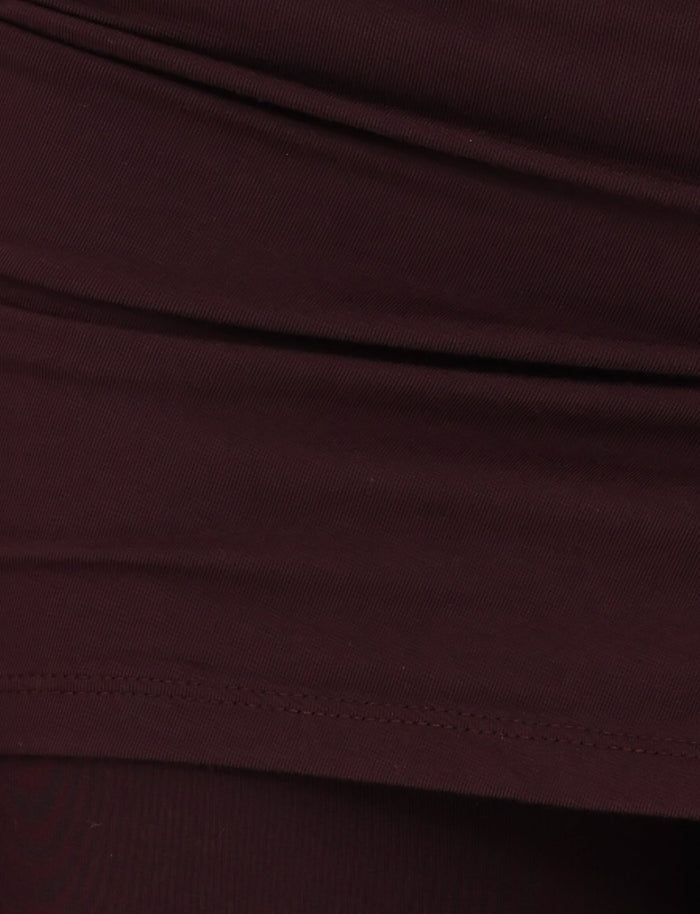 A detailed view of the LEILANI PANT - BROWN : CHOCOLATE from TIGERMIST highlights the visible stitching and folds, indicative of apparel. The fabric has a smooth texture with a bit of elasticity, suggesting it's made from high-stretch material ideal for comfort and fit.