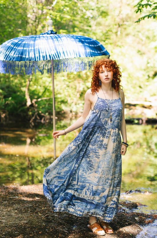 Model wearing Let the Light In bamboo viscose slip dress featuring print of Delft blue and white landscape pottery, and positive message of light and hope - Market of Stars