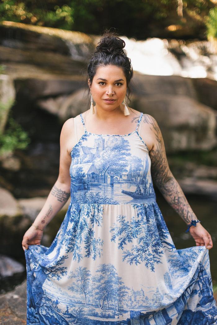 Model wearing Let the Light In bamboo viscose slip dress featuring print of Delft blue and white landscape pottery, and positive message of light and hope - Market of Stars